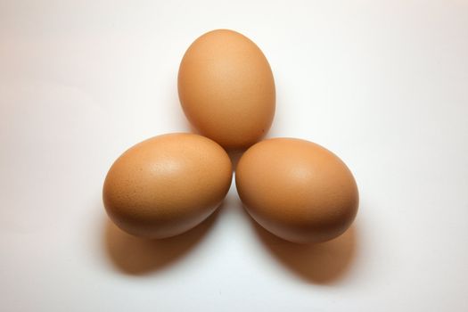 Three eggs positioned in a triangular shape isolated on white