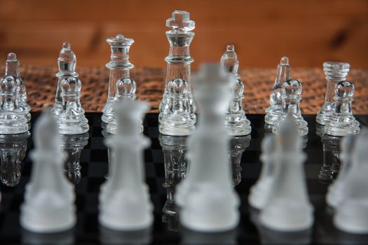 Glass chess set on a black marble board