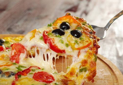 home pizza with tomato and eggplant  Closeup .taking slice of pizza,melted cheese dripping