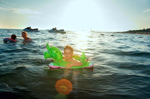 Little boy in the waves on the sea beach