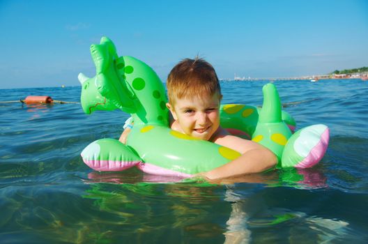 Little boy in the waves on the sea beach