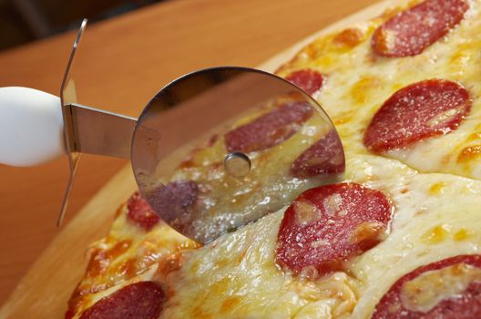 homemade pizza  Pepperoni.Closeup  a knife cut the pizza 
