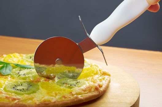homemade sweet pizza with fruit.Closeup  a knife cut the pizza 