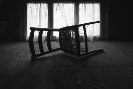 a chair whit web in the attic near a window