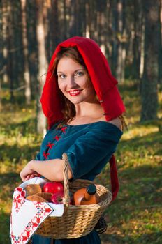 red Riding  hood standing in a wood . beautiful girl in medieval dress