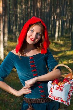 red Riding  hood standing in a wood . beautiful girl in medieval dress