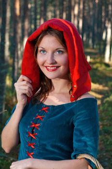 red Riding  hood standing in a wood . beautiful girl in medieval dress