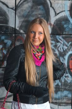 beauty young blonde woman posing in front of colorful grafitti 