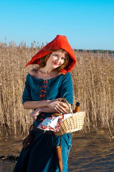 red Riding  hood standing in a wood . beautiful girl in medieval dress