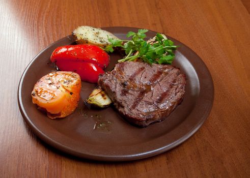 Grilled beef on white plate  with vegetable . Close-up
