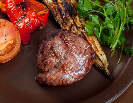 Grilled beef on white plate  with vegetable.closeup