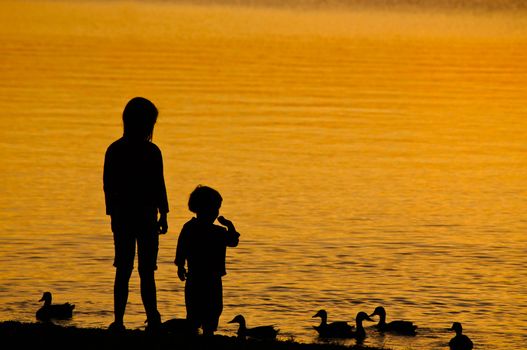 Two Children feeding the Duck at Sunset