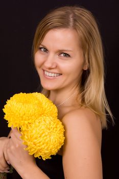 Romantic image of a young woman with yellow chrysanthemums.
