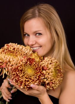 Romantic image of a young woman with yellow chrysanthemums.
