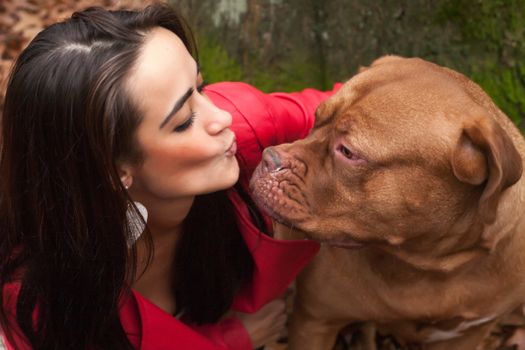 Young woman is having fun with her dog in the forest