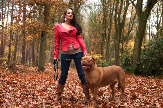 Young woman is having fun with her dog in the forest