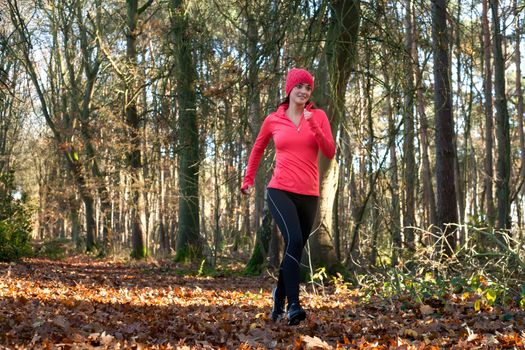 Young woman is working on her body in the forest