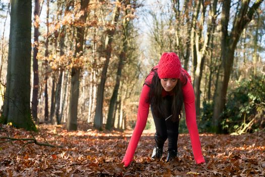 Young woman is working on her body in the forest