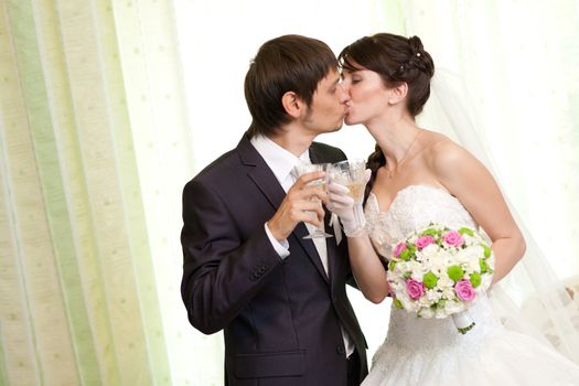 kissing bride and groom with champagne