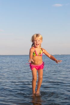 happy girl jumping in water at the evening