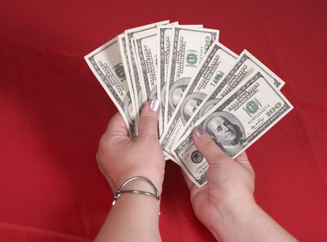 Hands and dollars on a red background