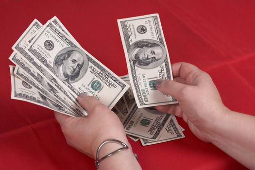 Hands and dollars on a red background