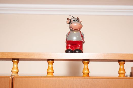 Statuette of the cheerful man on a wooden shelf
