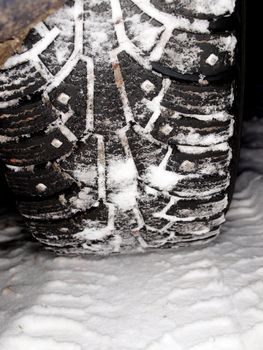 Studded winter tires, isolated on top of snow covered ground