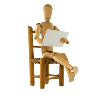 wooden puppet reading a notice on white paper