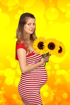 The pregnant woman holds in hands of sunflower