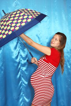 A pregnant woman and umbrella on a blue background