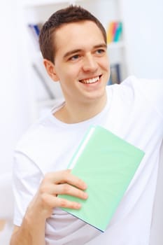 Young handsome man at home with a book