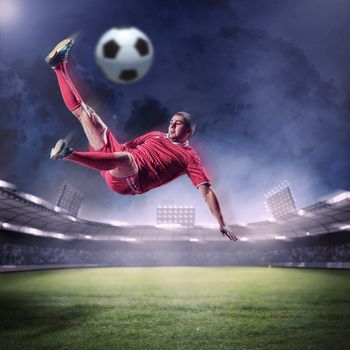 football player in red shirt striking the ball at the stadium