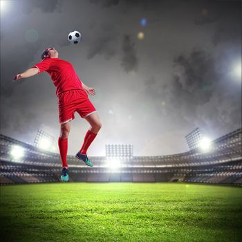 football player in red shirt striking the ball at the stadium