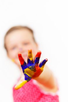 little child with hands painted in colorful paints ready for hand prints