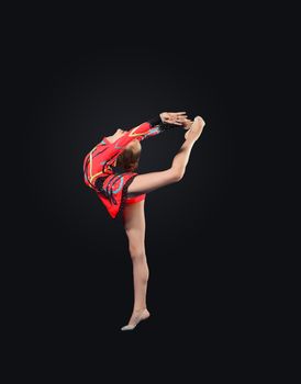 Young cute woman in gymnast suit show athletic skill on black background