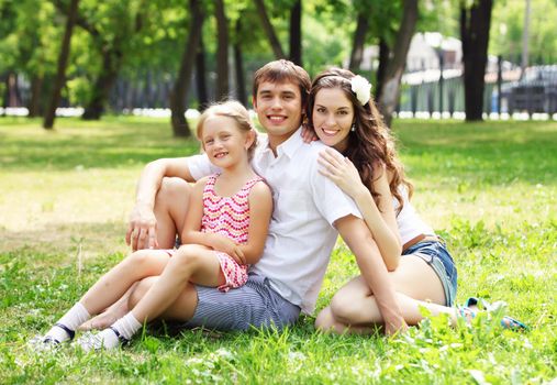 Young Family Outdoors on the grass in Park in summer