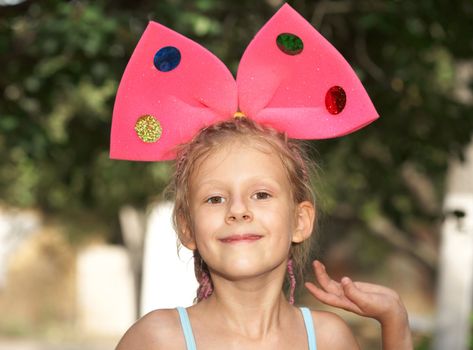 The the small girl with red bow on a head