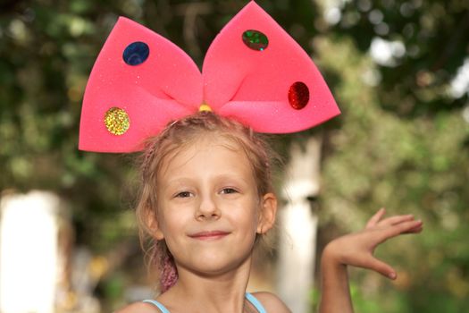 The the small girl with red bow on a head