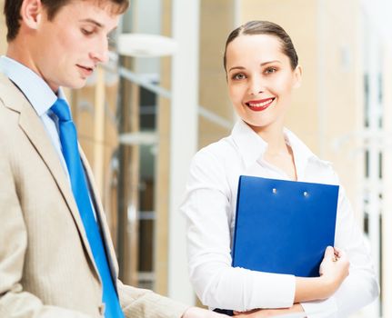 two businessmen standing in the office with documents