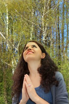 Outdoors portrait of the beautiful woman. Grateful pray.