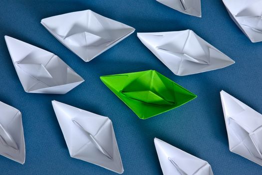White paper boats and one green boat.
