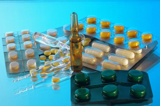 Medicine. Tablets and ampoules  on a blue background