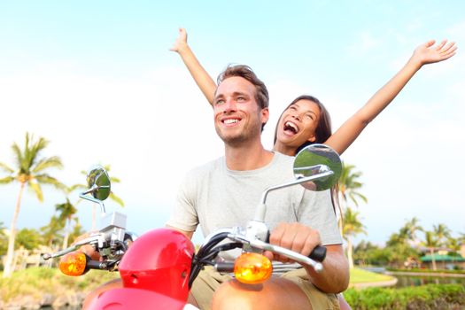 Happy free freedom couple driving scooter excited on summer holidays vacation. Young multiethnic couple, Asian woman, Caucasian man