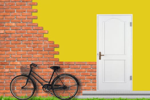 Brick wall and white closed doors. Bicycle near house