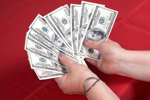 Dollars and hands on a red background