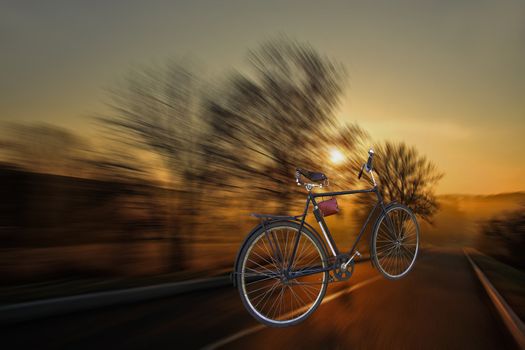The bicycle quickly rushes on a highway. Sunset