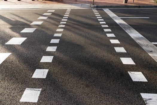 empty sidewalk and road asphalt with white pedestrian line