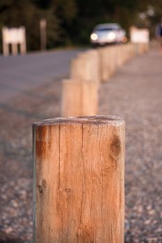 Short wooden posts in a line that serve as a barrier on a road