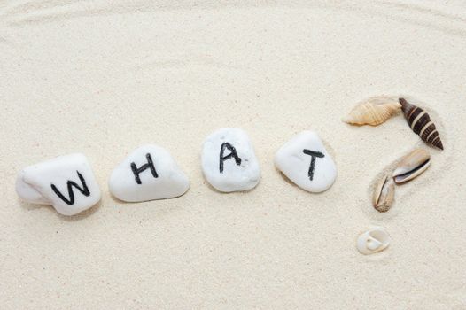 What word on group of stones and question mark made of shells  with sand background